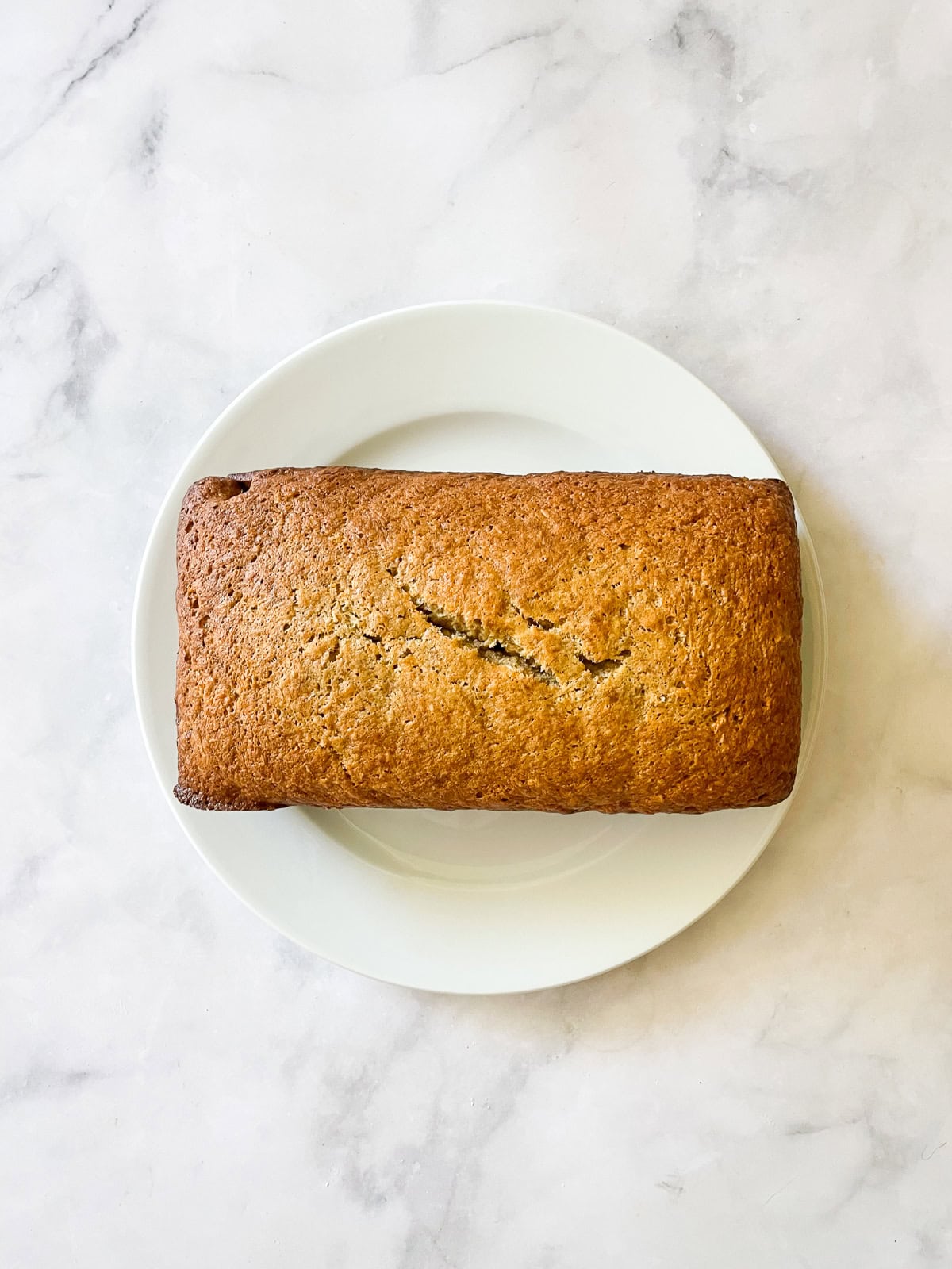 This recipe for gluten free coconut banana bread produces a beautiful loaf with a dense, moist crumb that's swirled with shredded coconut. A loaf of coconut banana bread.