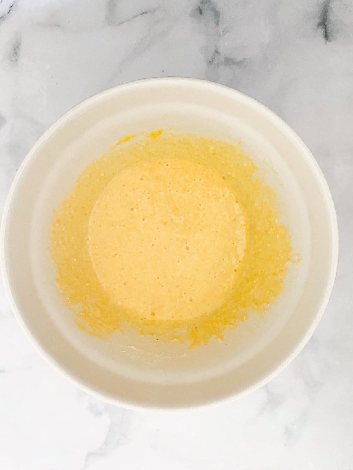 This gluten-free maple cornbread is tender-crumbed perfection thanks to buttermilk. Naturally sweetened with pure maple syrup! Gluten free maple cornbread batter in bowl.