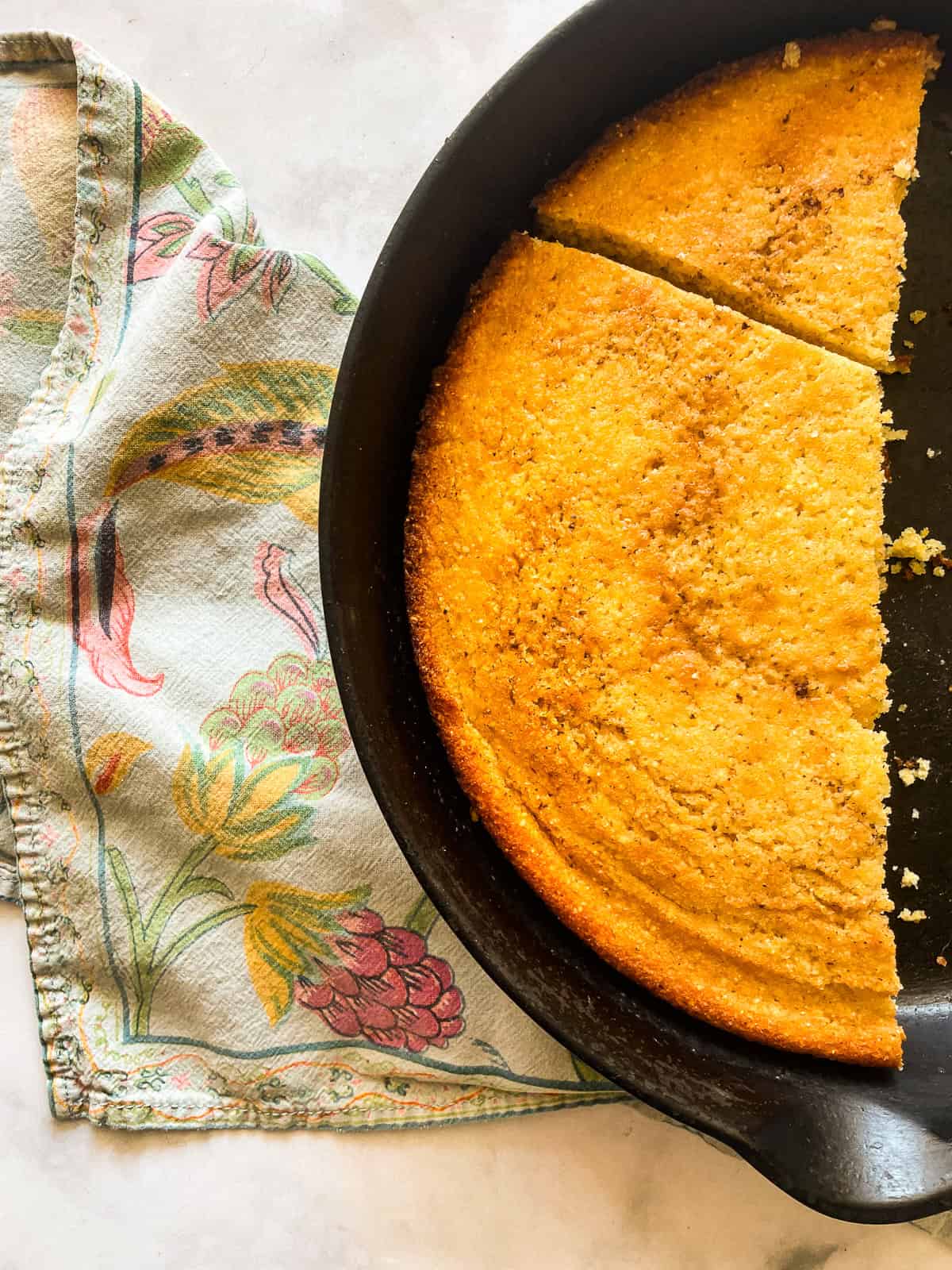 This gluten-free maple cornbread is tender-crumbed perfection thanks to buttermilk. Naturally sweetened with pure maple syrup! Half a pan of gluten free maple cornbread.