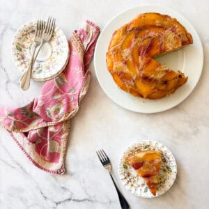Plates with forks wait for slices of gluten free nectarine cake.