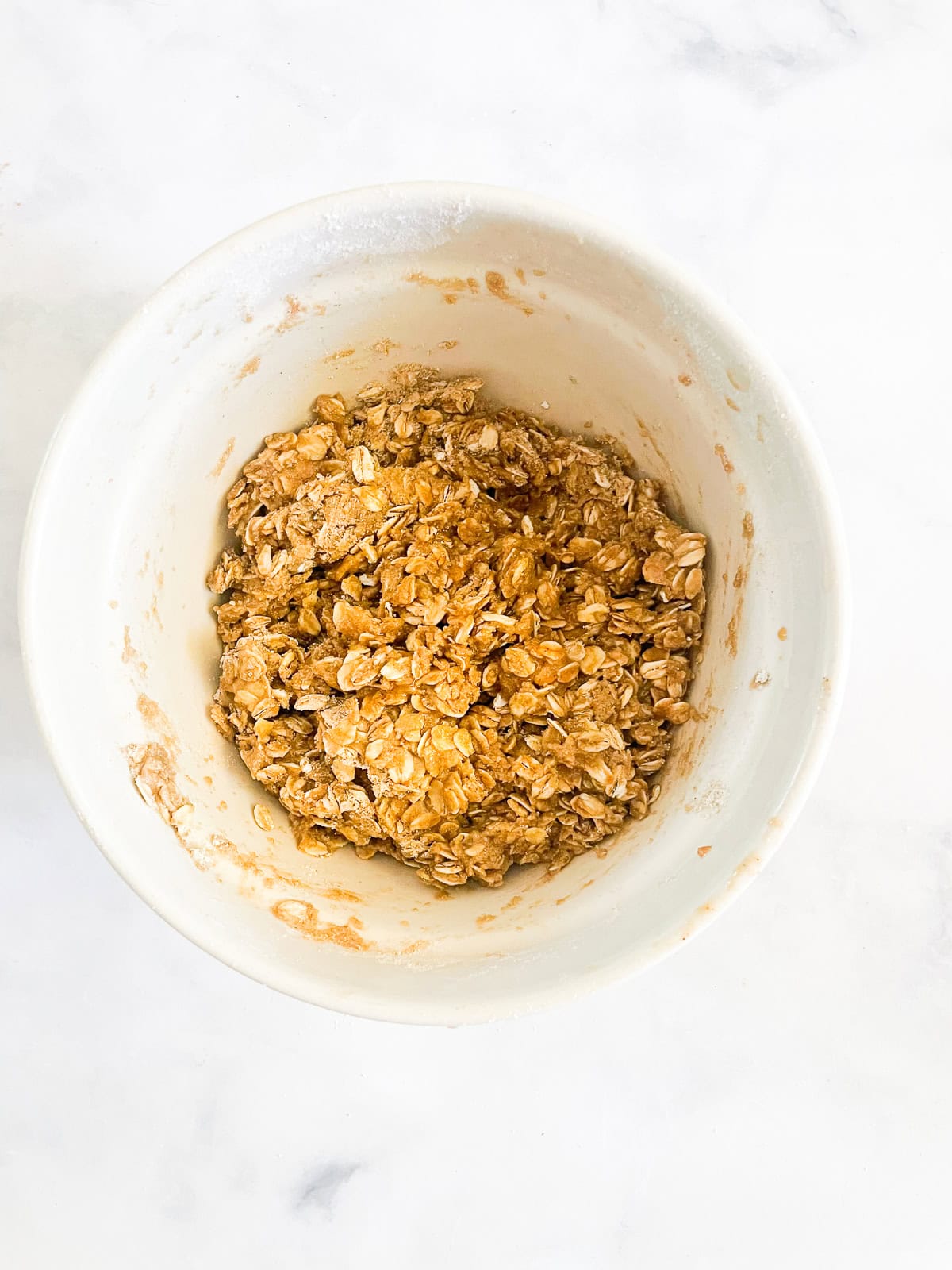 This beautifully simple gluten free nectarine crisp highlights ripe summer stone fruit. Add fresh rosemary for a lovely herbal touch. Topping for gluten free nectarine crisp in a bowl.