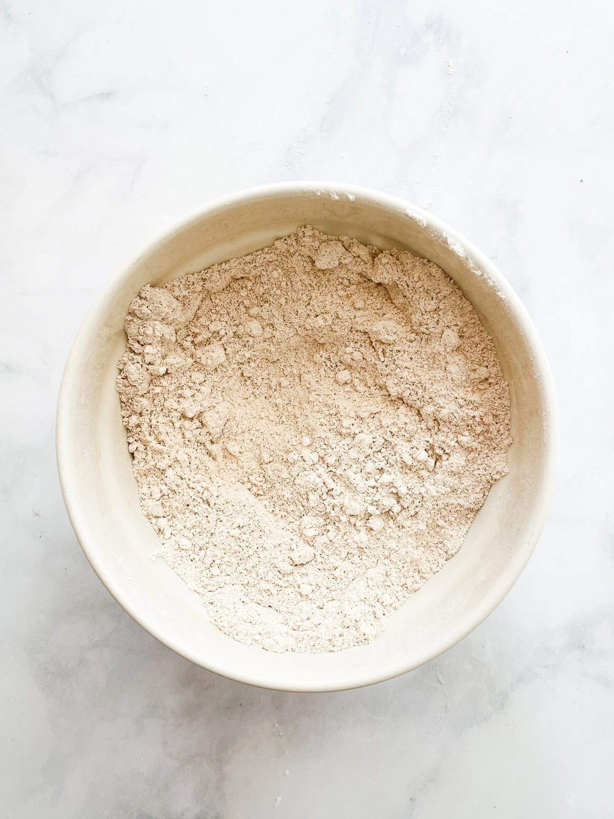 A soft and sumptuous gluten free pumpkin donut cake is bathed in cinnamon-sugar for a fabulous fall treat. Flour mix in a bowl for gluten free pumpkin donut cake.