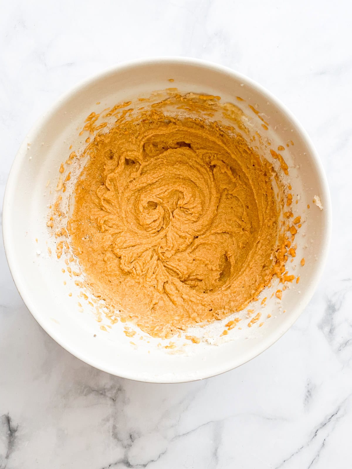 A soft and sumptuous gluten free pumpkin donut cake is bathed in cinnamon-sugar for a fabulous fall treat. The batter for gluten free pumpkin donut cake in a bowl.