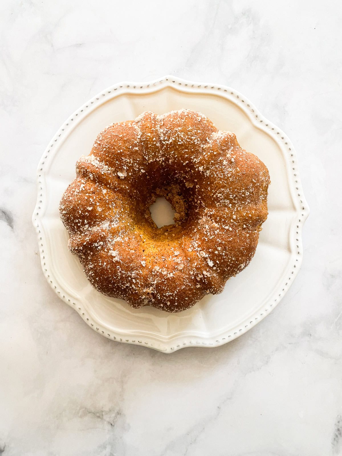 A gluten free pumpkin donut cake on a white plate.