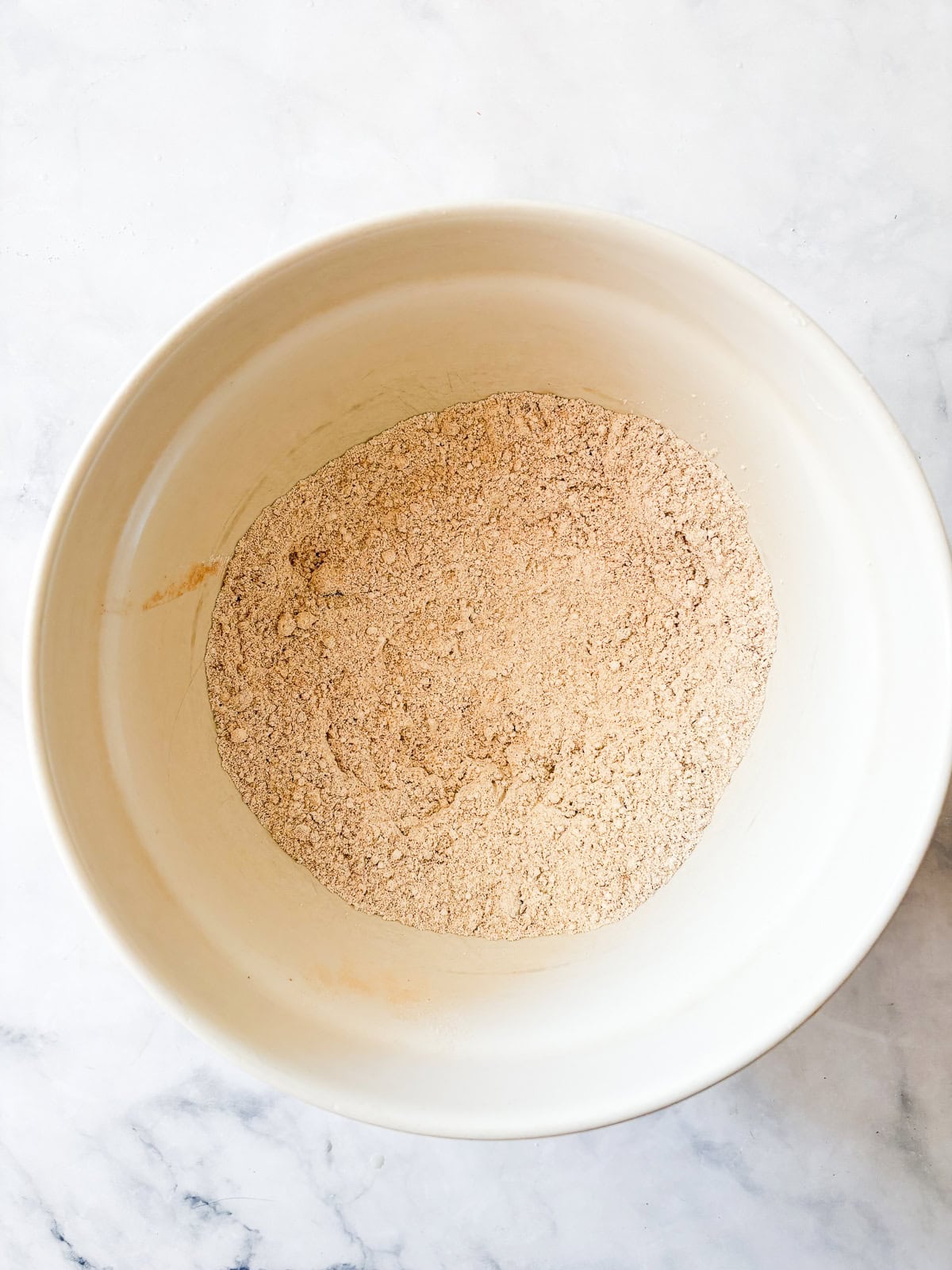 Soft and fluffy gluten free pumpkin pancakes are packed with plenty of fall flavor thanks to pumpkin puree, warming spices, and maple syrup! Dry ingredients for pumpkin pancakes mixed in a bowl.