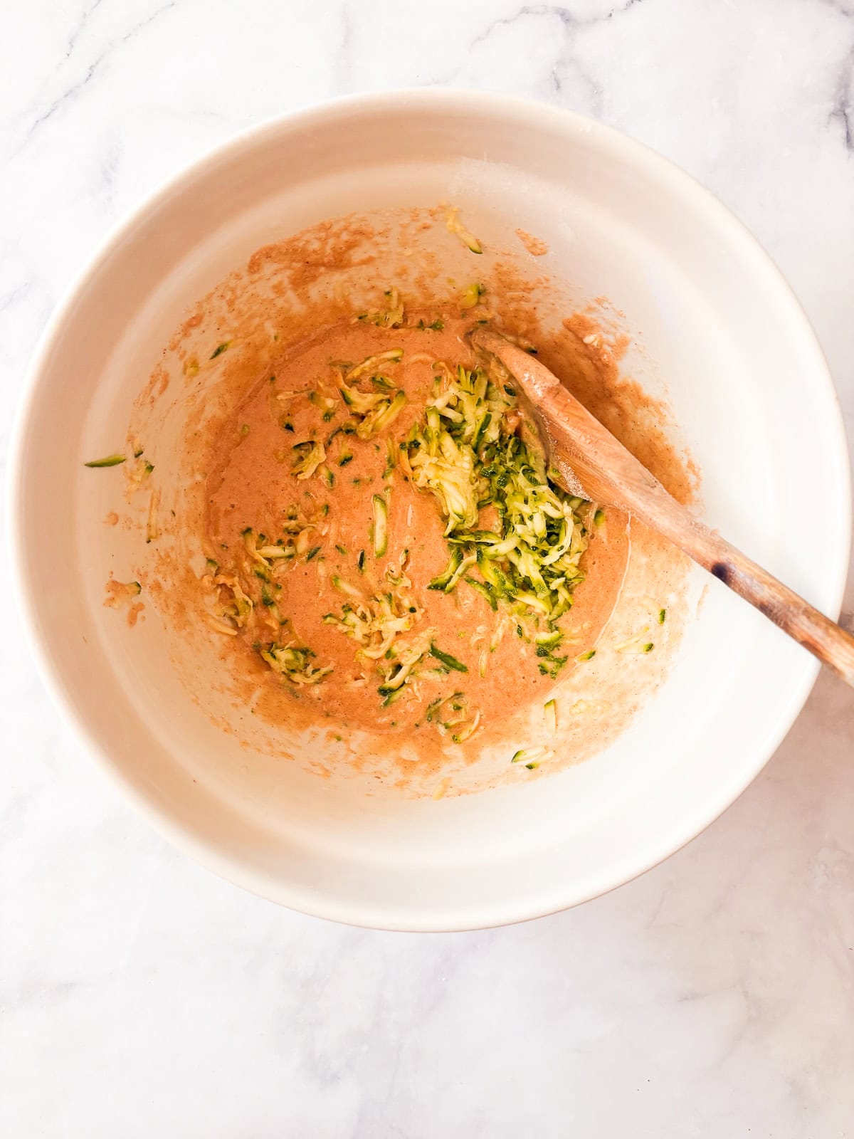 Tuck shredded squash into these gluten free zucchini chocolate chip muffins for a delectable morning treat. Zucchini is stirred into gluten free muffin batter.