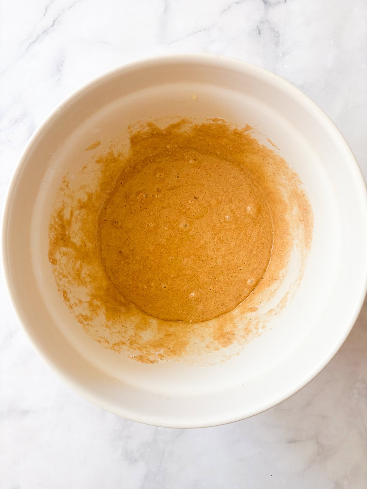 Tuck shredded squash into these gluten free zucchini chocolate chip muffins for a delectable morning treat. The batter for gluten free zucchini chocolate chip muffins in a bowl.