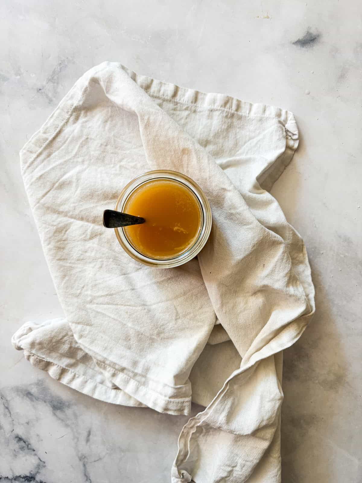 Silky and rich, this homemade salted caramel sauce is an absolute dream. Perfect over ice cream, waffles, cake, pancakes, and more. A jar of salted caramel sauce with a spoon in it.