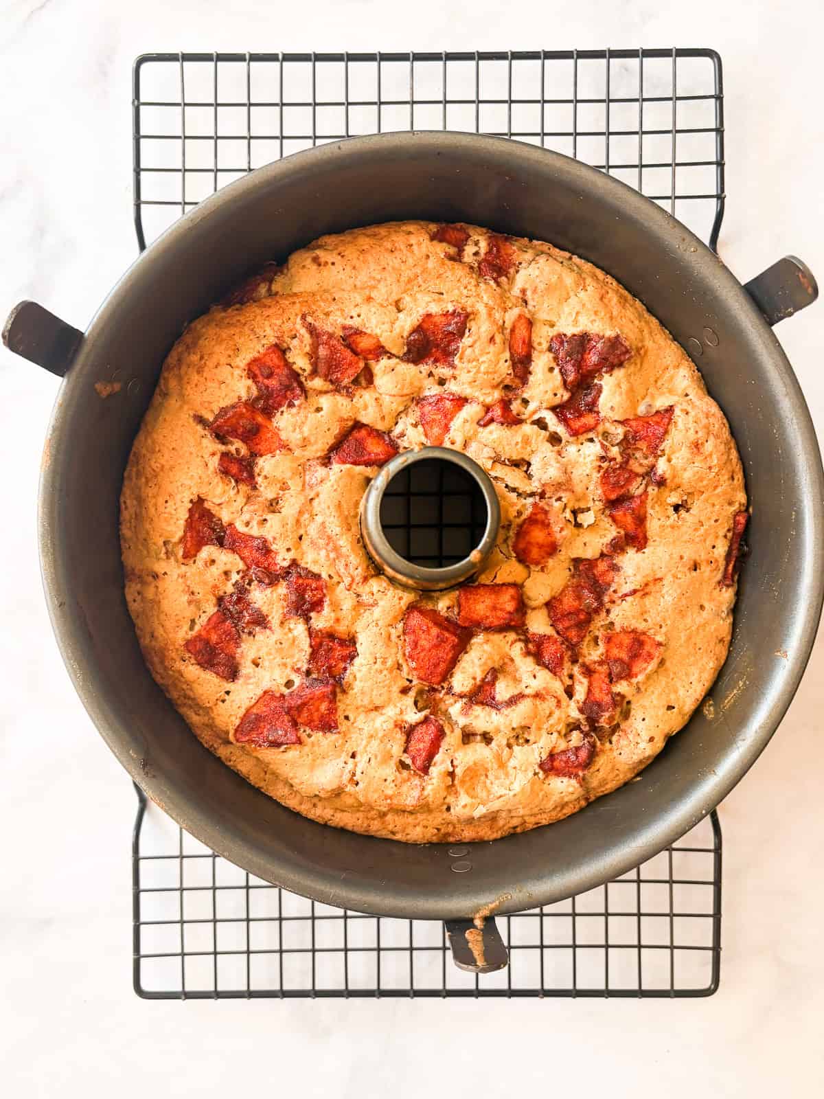 This homey gluten free one bowl apple cake is packed with whole-grain flour and juicy bites of cinnamon-spiked apples. Also dairy-free! An apple cake cools in a pan.