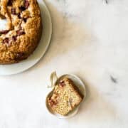 A slice of apple cake next to a plate of cake.
