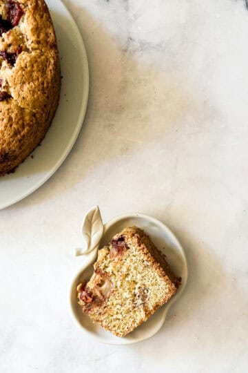 A slice of apple cake next to a plate of cake.