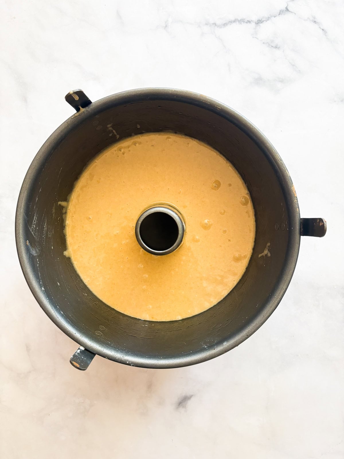 This homey gluten free one bowl apple cake is packed with whole-grain flour and juicy bites of cinnamon-spiked apples. Also dairy-free! Half of the cake batter in a tube pan.