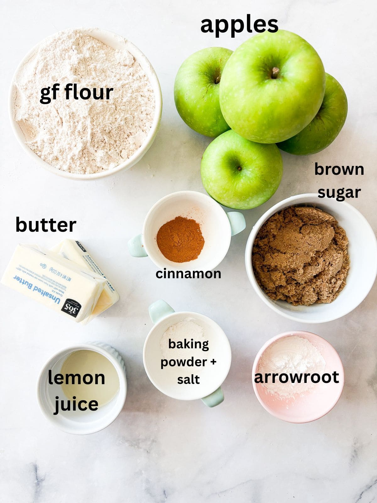 A crisp, buttery brown sugar streusel tops tender apples in this homey gluten free apple crumble. Perfect with vanilla ice cream! Ingredients for a gluten free apple crumble are text-labeled.