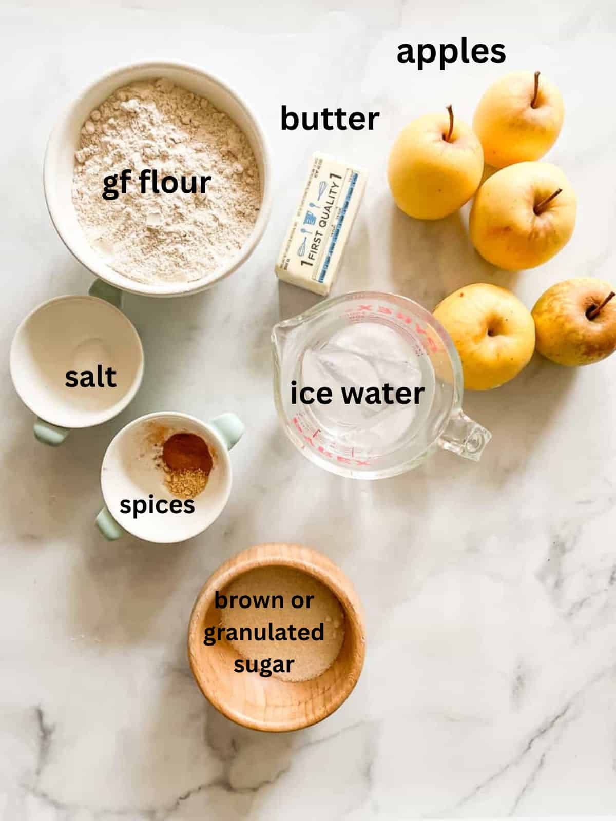 Rustic and beautiful, this gluten free apple galette wraps juicy, spiced apples in a buttery, flaky crust. Perfect for holiday gatherings! Ingredients for gluten free apple galette are text-labeled.