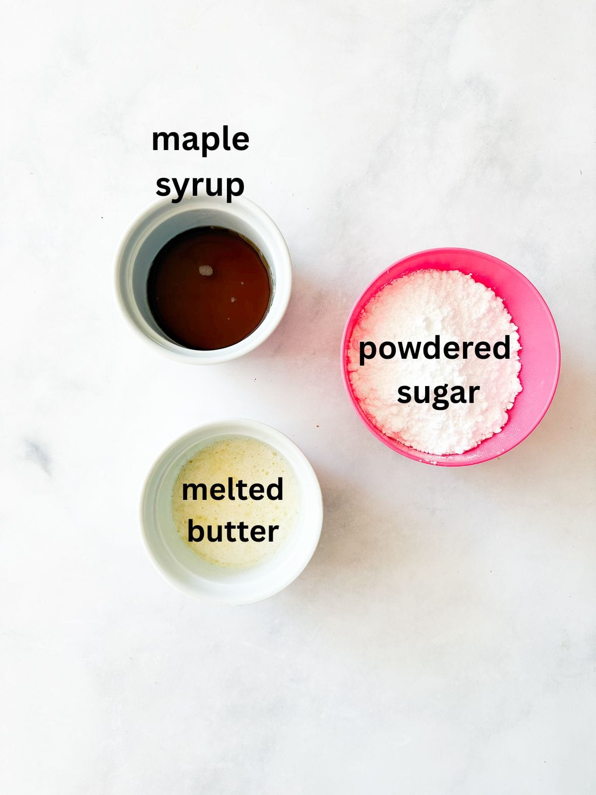 This smooth and luxurious maple glaze recipe needs just three simple ingredients to make and is wonderful on scones, pumpkin bread, and more. Ingredients for maple glaze are text-labeled.
