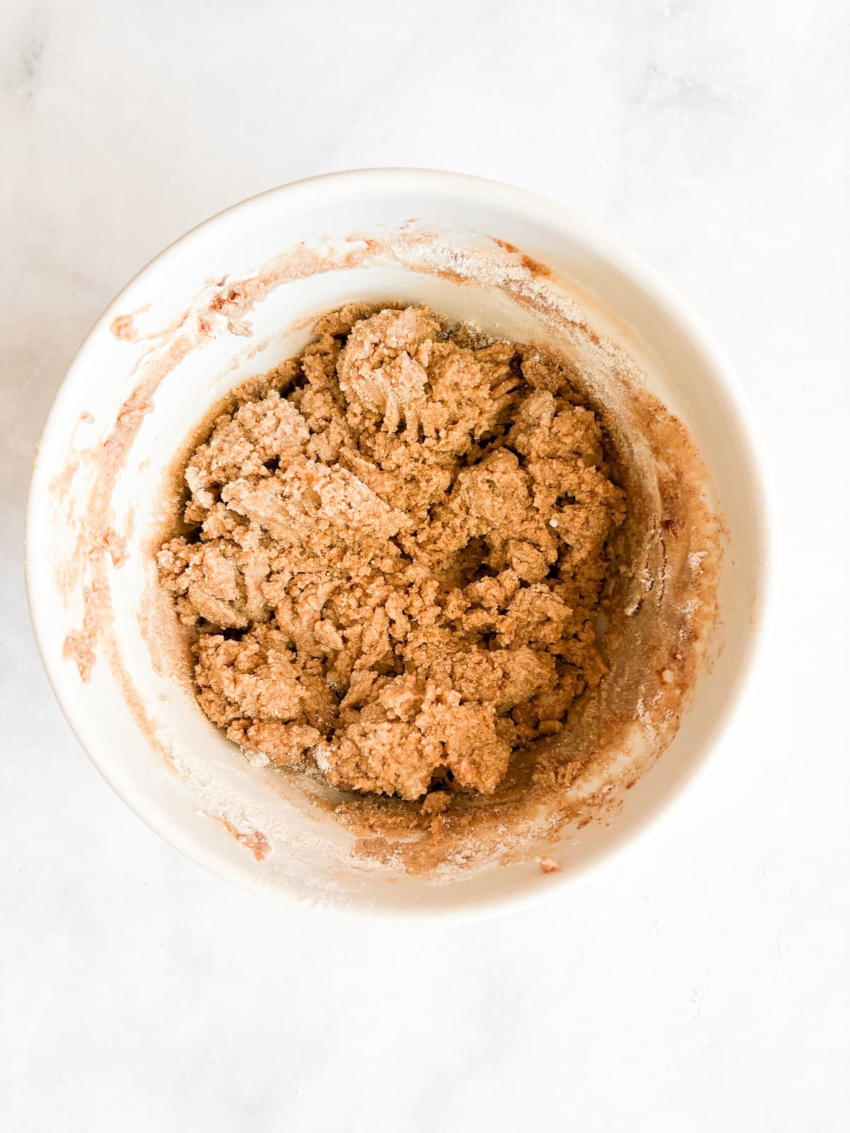 A crisp, buttery brown sugar streusel tops tender apples in this homey gluten free apple crumble. Perfect with vanilla ice cream! Gluten free apple crumble topping in a bowl.