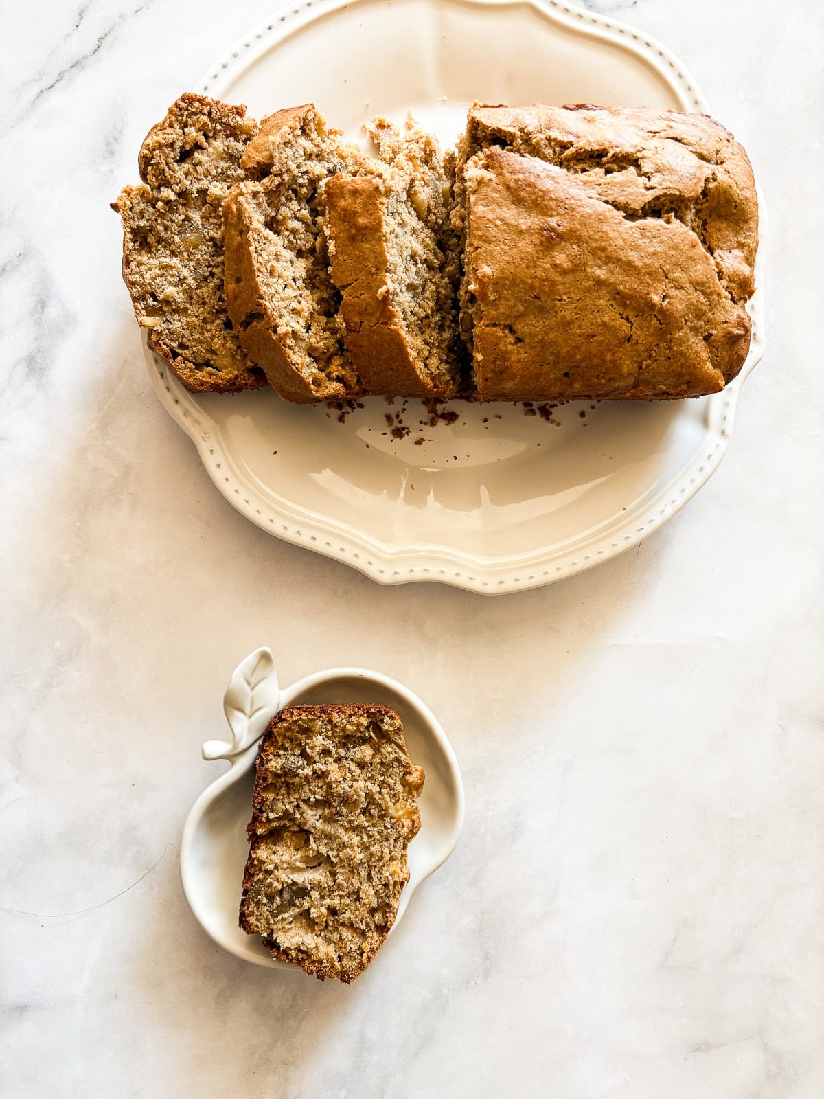 This beautifully simple yet deeply satisfying gluten free banana apple bread marries a classic banana bread with fresh for a twist. Slice of banana apple bread on plates.