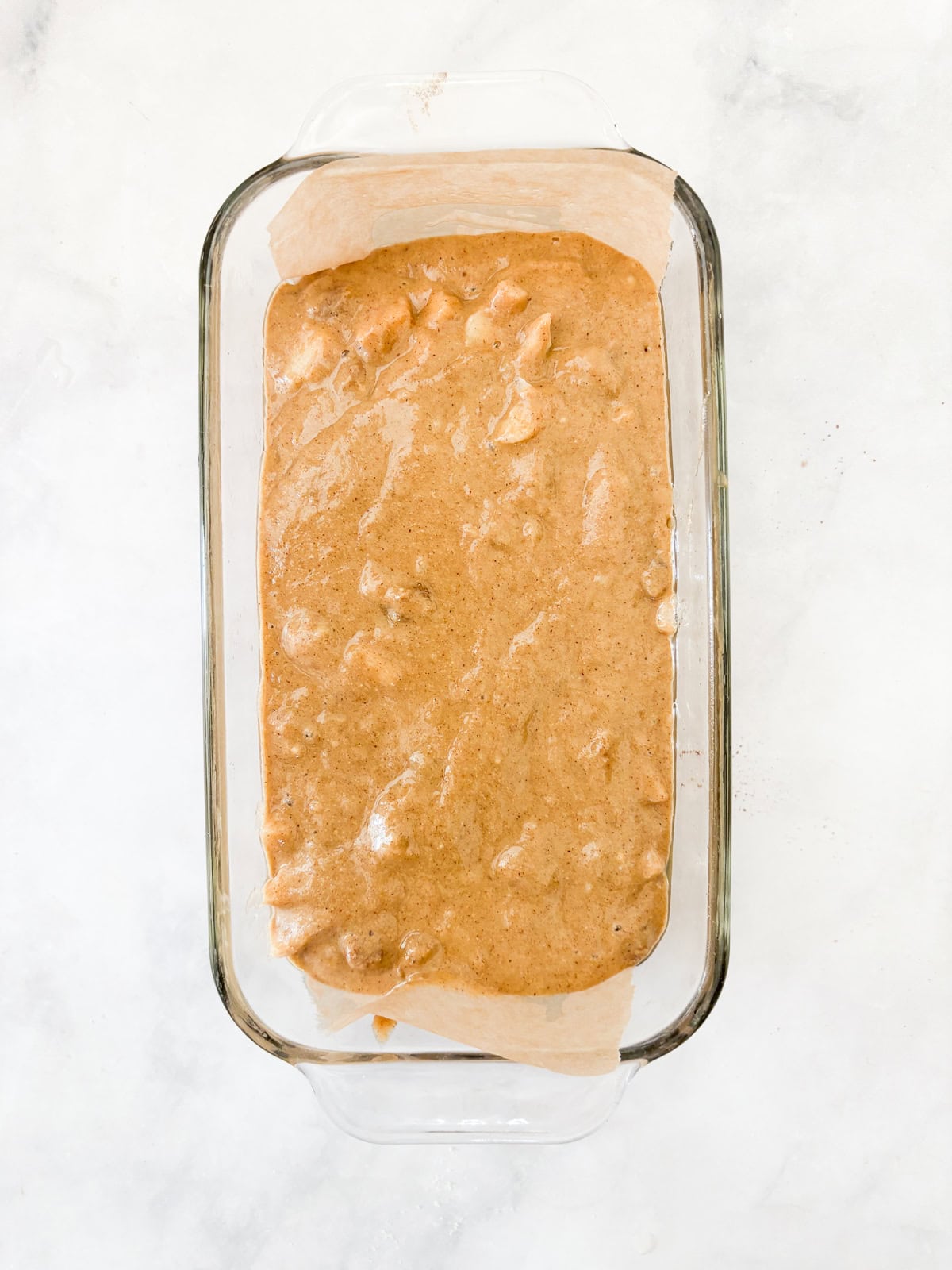 This beautifully simple yet deeply satisfying gluten free banana apple bread marries a classic banana bread with fresh for a twist. Banana apple bread batter added to a lined loaf pan.