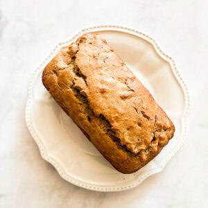 A loaf of gluten free banana apple bread on a plate.