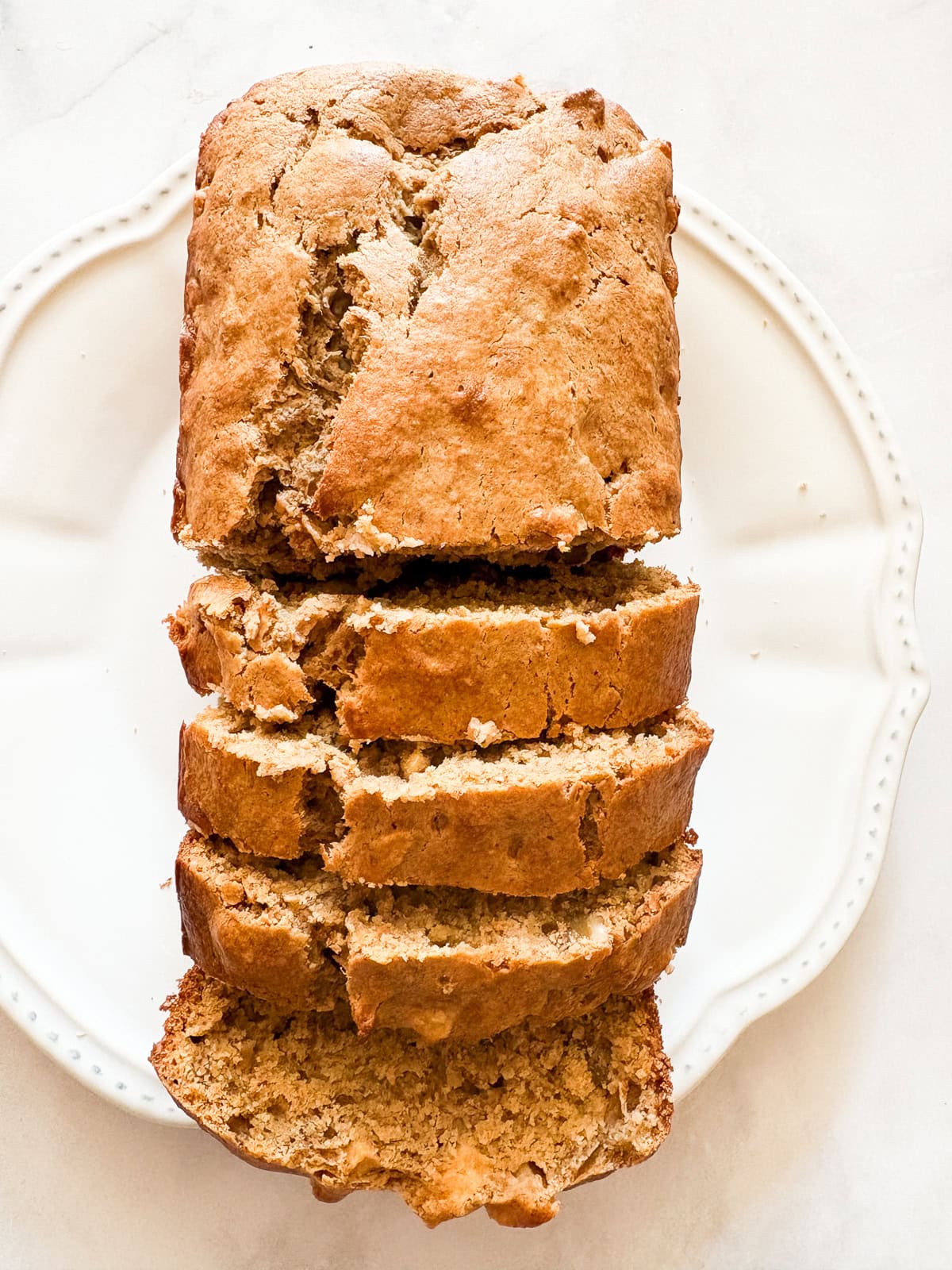 This beautifully simple yet deeply satisfying gluten free banana apple bread marries a classic banana bread with fresh for a twist. A sliced loaf of gluten free banana apple bread.