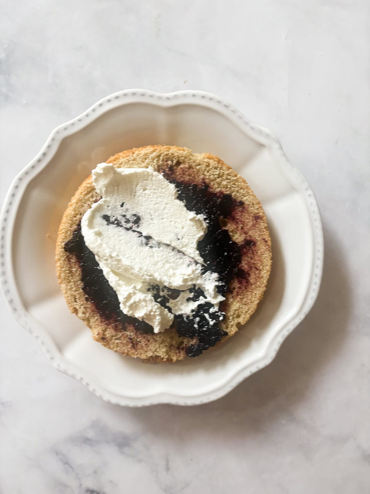A tender gluten-free blackberry jam cake layered with whipped cream and jam that's fresh, light, and perfect for summer. Whipped cream spread on top of blackberry jam and cake.