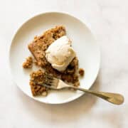 A gluten free pumpkin square on a plate with ice cream and a fork.