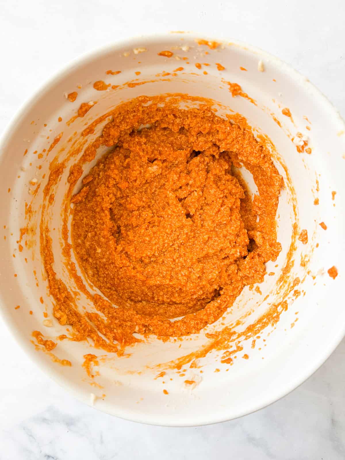 These soft-baked gluten free pumpkin chocolate chip cookies are packed with pumpkin puree, warm spices, and semisweet chocolate. Pumpkin mixed with butter in a bowl.