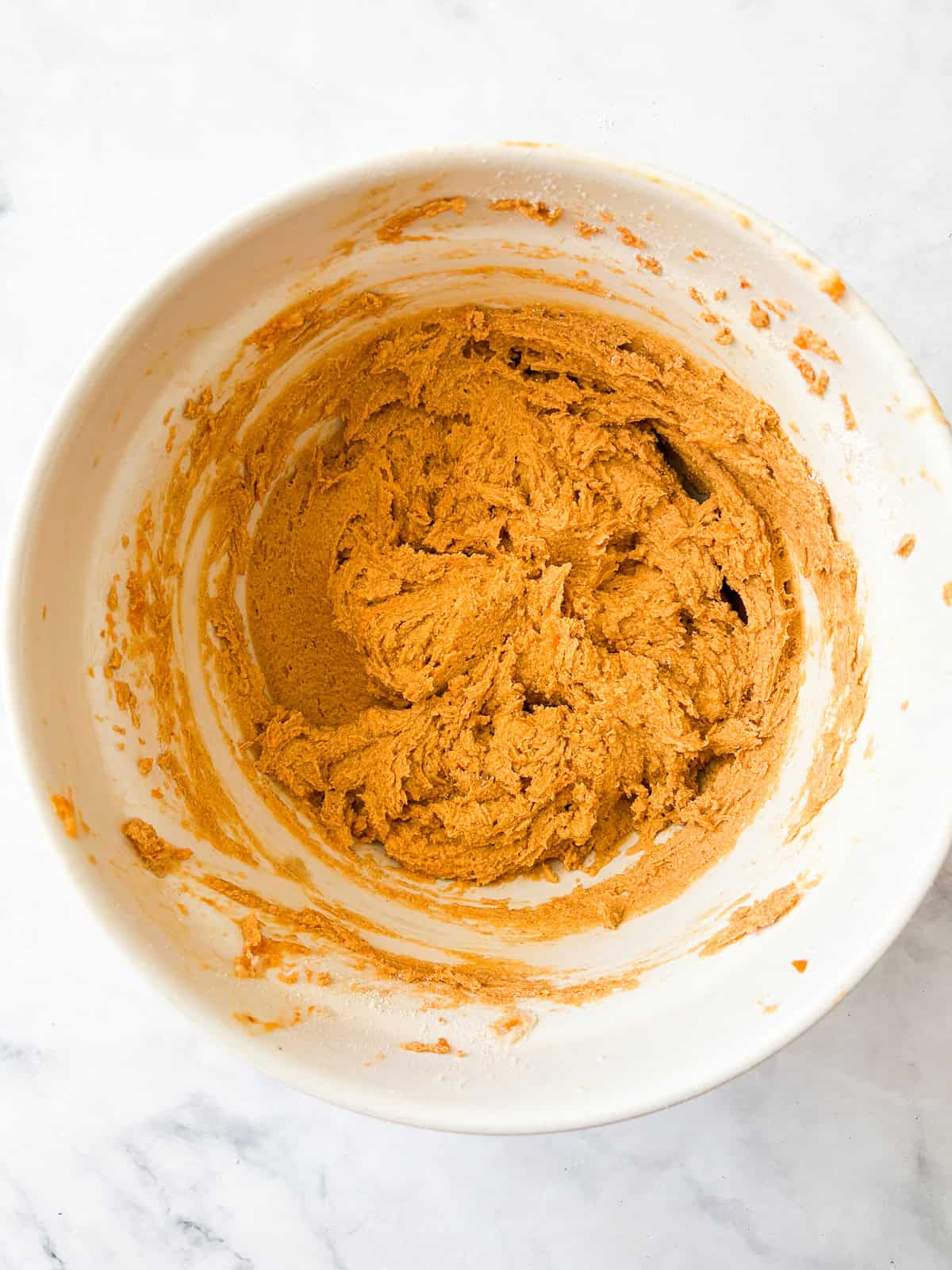 These soft-baked gluten free pumpkin chocolate chip cookies are packed with pumpkin puree, warm spices, and semisweet chocolate. The batter for gluten free pumpkin chocolate chip cookies in a bowl.