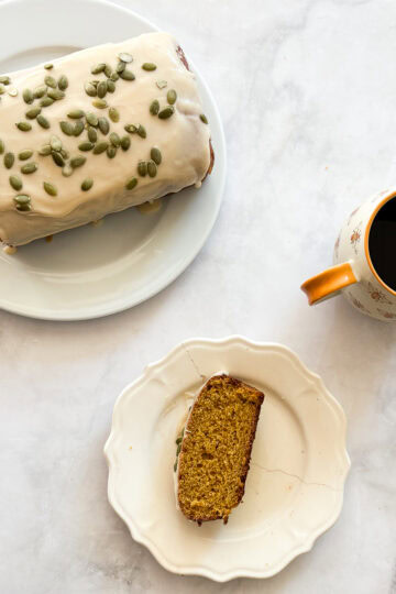 A cup of coffee and a gluten free pumpkin loaf cake.