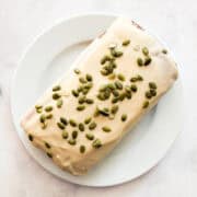 Pumpkin seeds top a gluten free pumpkin loaf cake with maple glaze.
