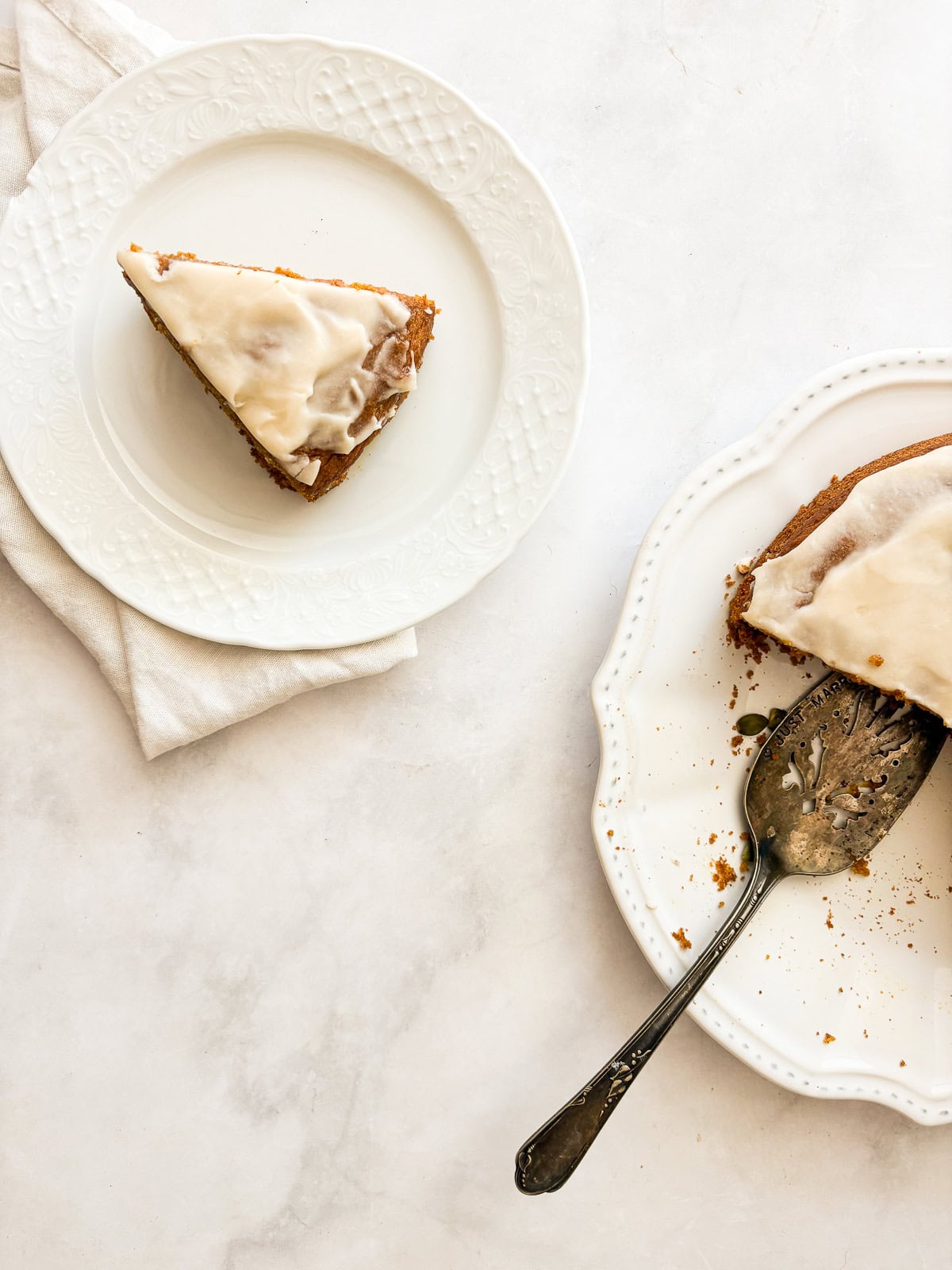 A thick maple glaze tops a soft gluten free pumpkin olive oil cake that's dairy-free, made in one bowl, and utterly delicious! A slice of pumpkin olive oil cake on a plate next to a cake with a server.