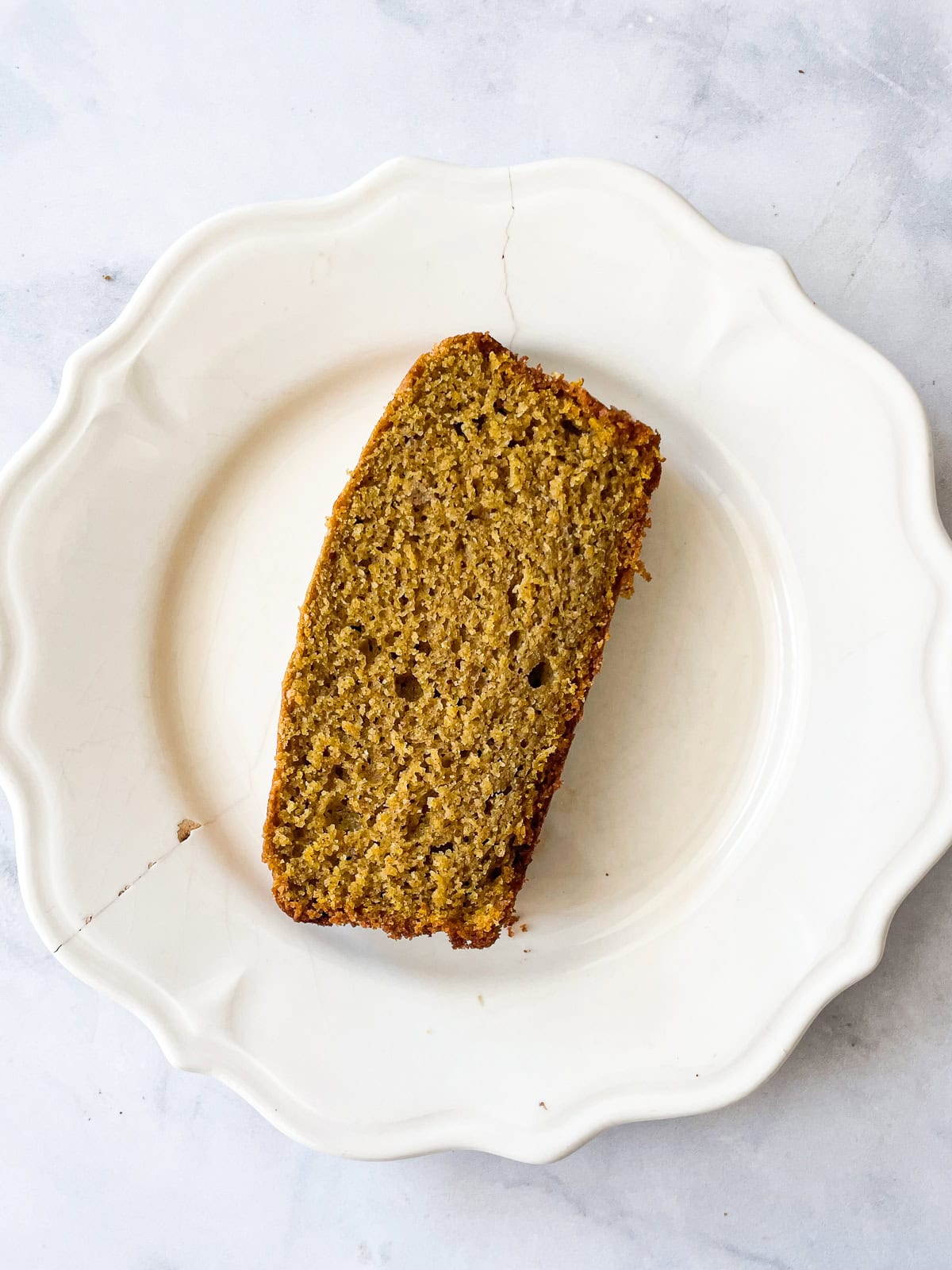 A slice of oat flour pumpkin bread on a plate.