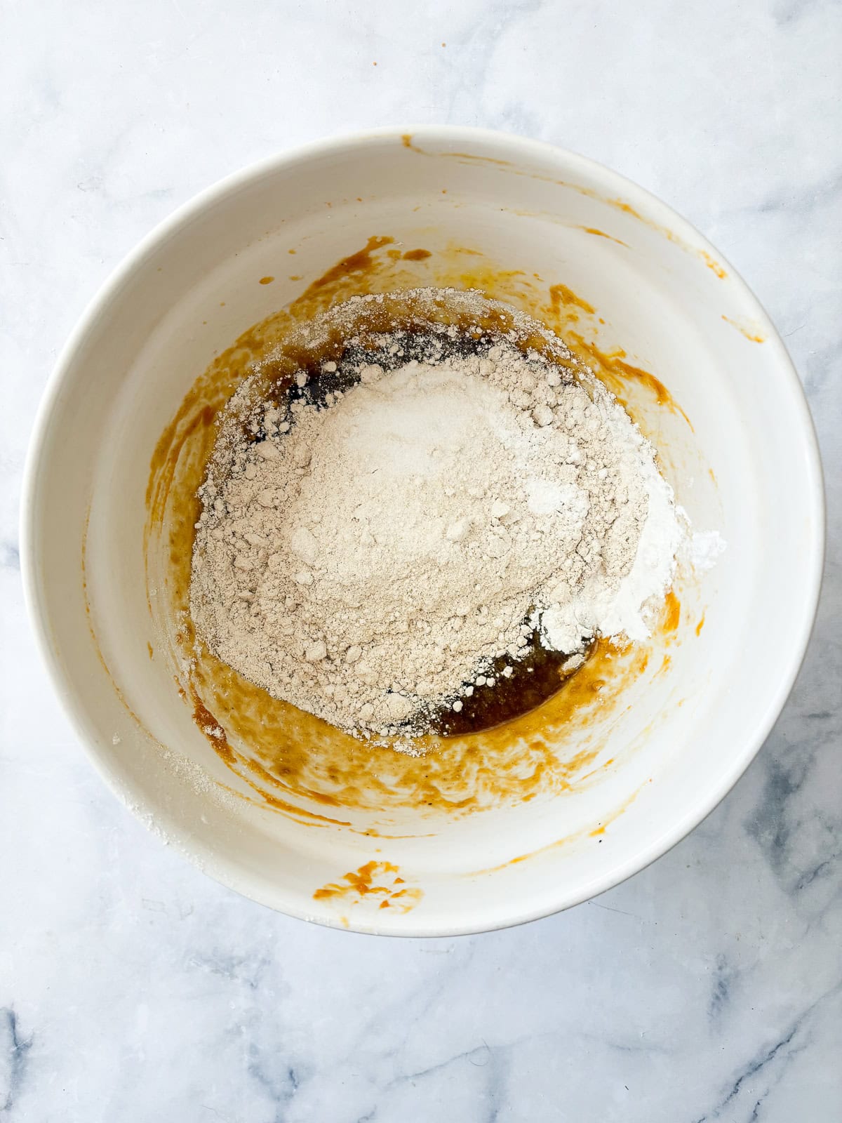 Ingredients are combined in a bowl for oat flour pumpkin bread.