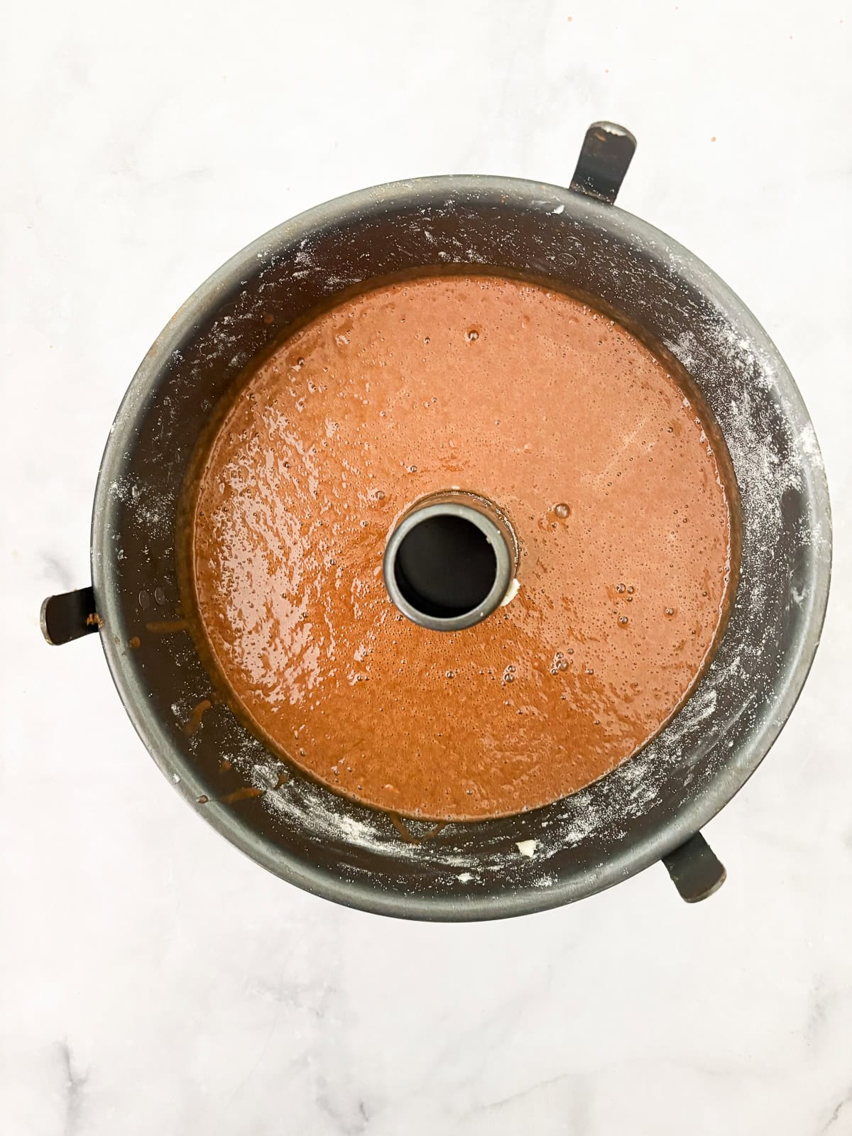 This gluten-free chocolate dump cake hits all the notes you want in a gluten-free cake - fudgy crumb, dense chocolate flavor, and creamy icing. The dump cake batter is dumped into a tube pan.