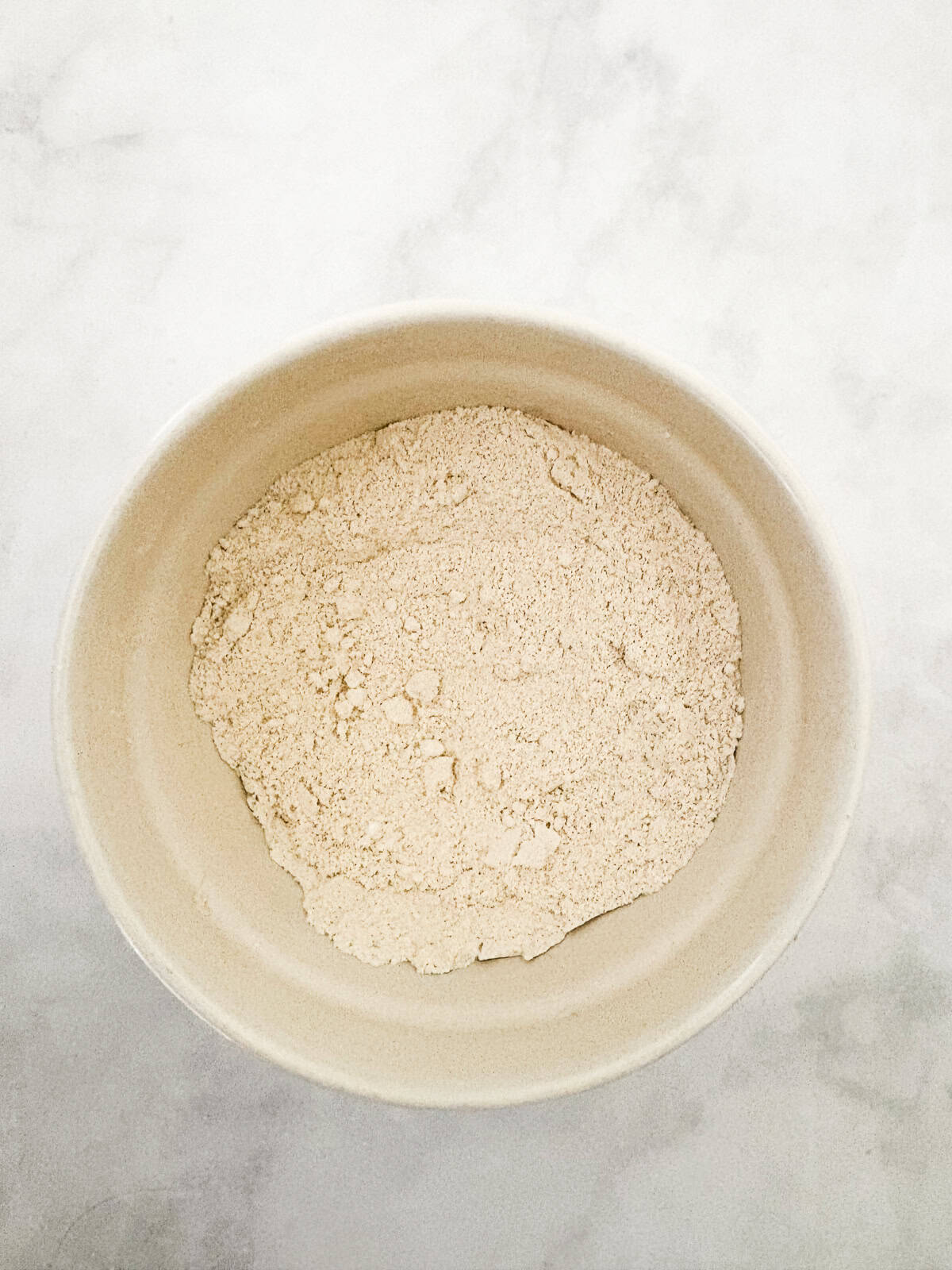 This gluten-free chocolate dump cake hits all the notes you want in a gluten-free cake - fudgy crumb, dense chocolate flavor, and creamy icing. The dry mix for gluten free chocolate dump cake in a bowl.