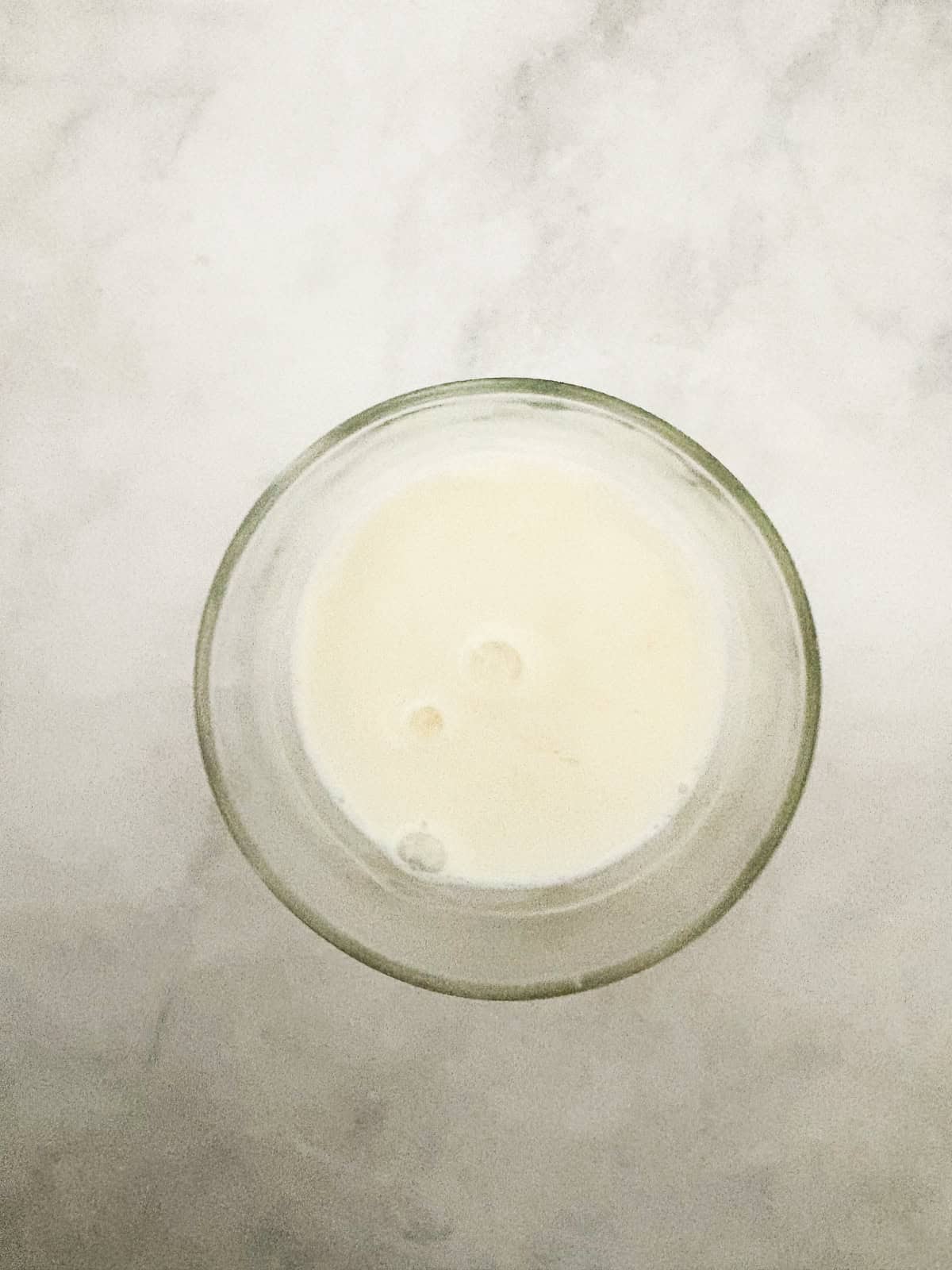 This gluten-free chocolate dump cake hits all the notes you want in a gluten-free cake - fudgy crumb, dense chocolate flavor, and creamy icing. Milk is mixed with vinegar in a glass.