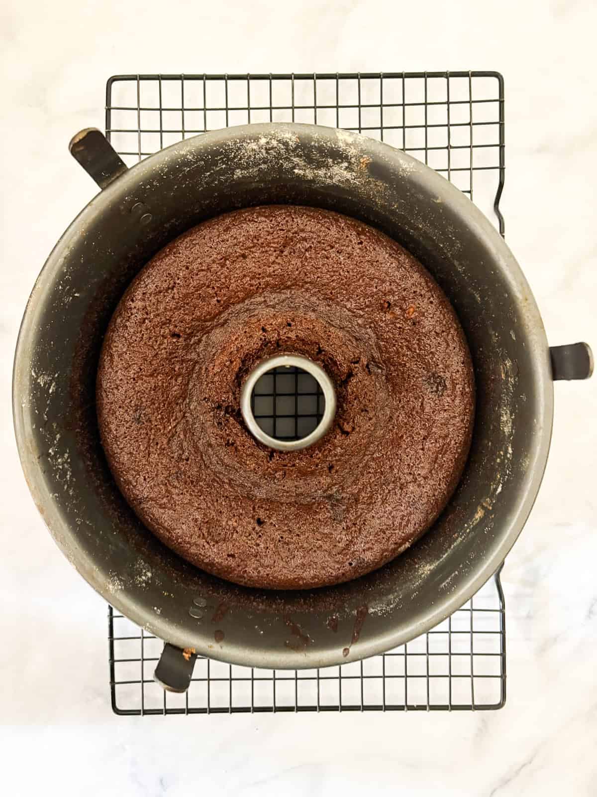 This gluten-free chocolate dump cake hits all the notes you want in a gluten-free cake - fudgy crumb, dense chocolate flavor, and creamy icing. A gluten free chocolate dump cake cools in the pan.