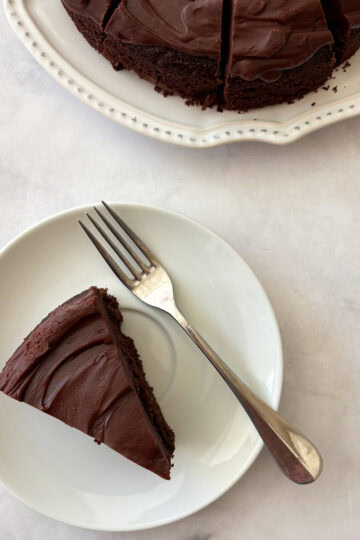 A plate with a slice of gluten free olive oil cake and a fork.