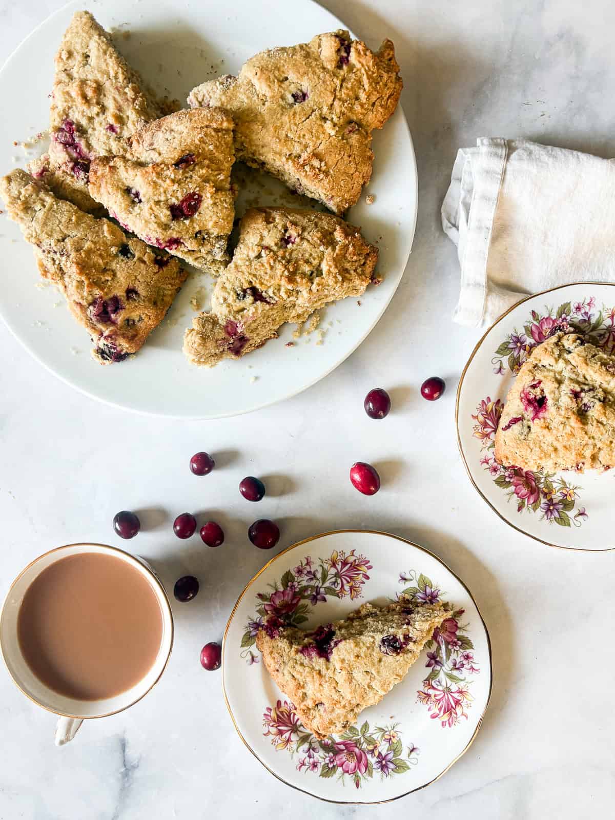 A plated of gluten free cranberry scones, two plates with scones, and tea.
