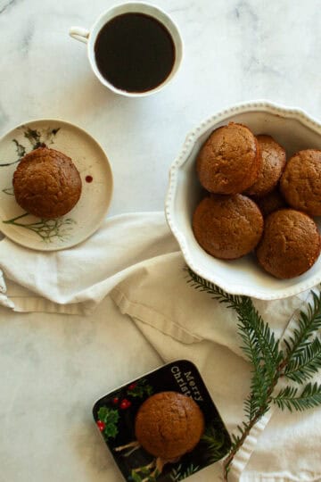 Gluten free gingerbread muffins on plates next to a bowl of muffins.