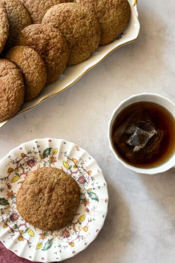 A cup of tea next to gluten free snickerdoodles.