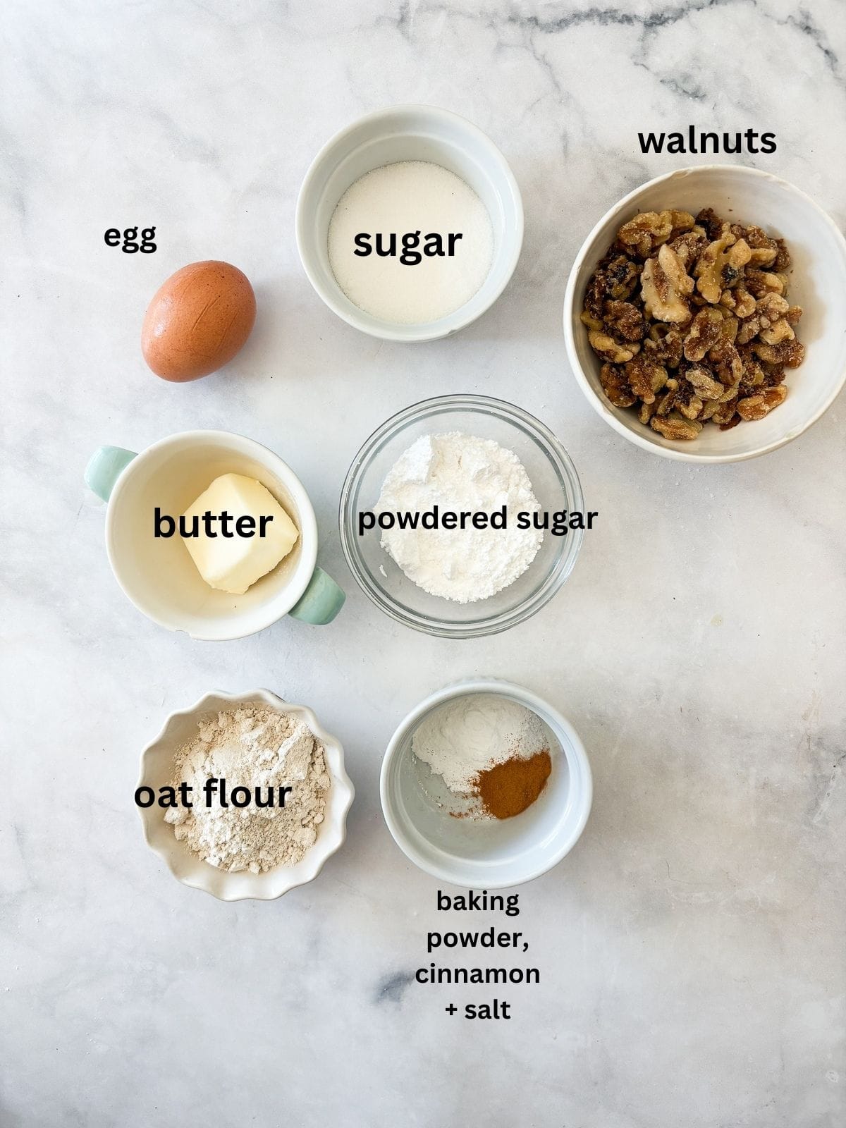 Chewy Moroccan ghriba cookies with walnuts and cinnamon are lightly sweet, rolled in powdered sugar, and easily gluten-free. Ingredients for ghriba cookies are text-labeled.