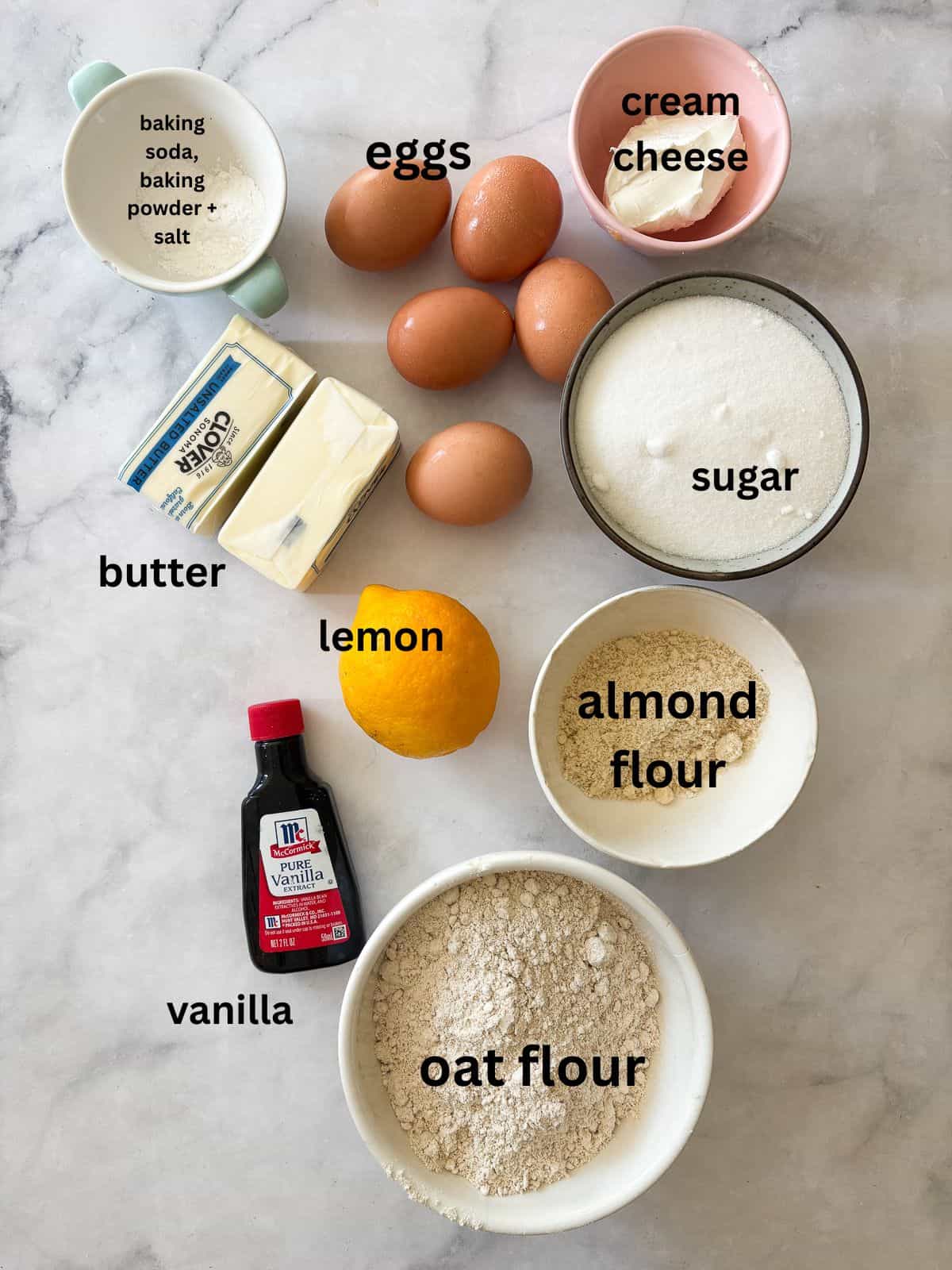 This rich and velvety gluten free lemon pound cake stays moist and tender for days! Made with oat and almond flour, cream cheese, and butter! Ingredients for gluten free lemon pound cake are text-labeled.