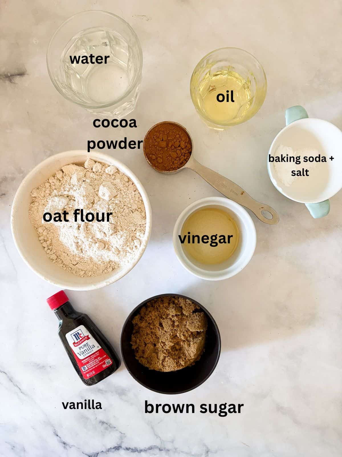 Delicious one-bowl vegan gluten-free chocolate cupcakes are made with oat flour and a handful of simple ingredients. So soft and fluffy! The ingredients for vegan gluten-free chocolate cupcakes are text-labeled.