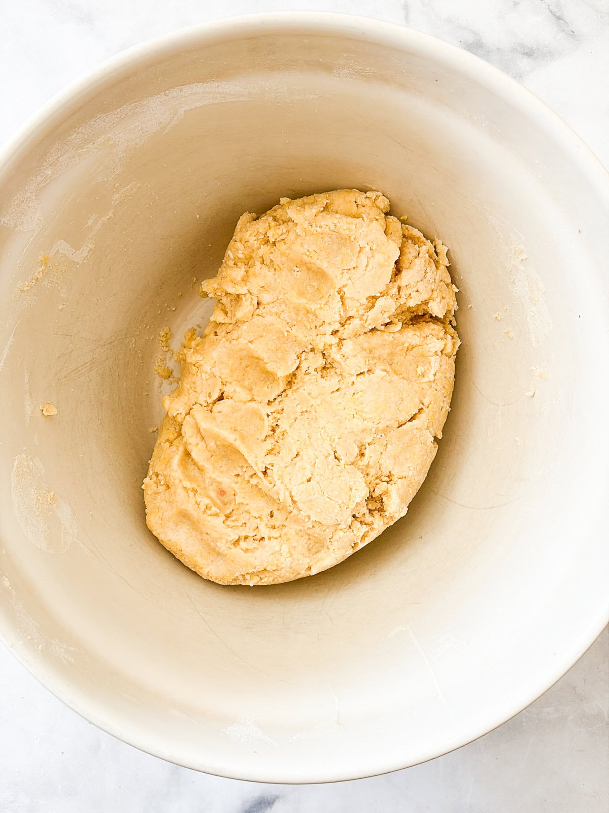 These not-too-sweet Italian sugar cookies, called befanini, are topped with sprinkles and are so fun to make with kids! Easily gluten-free. Befanini dough in a bowl.