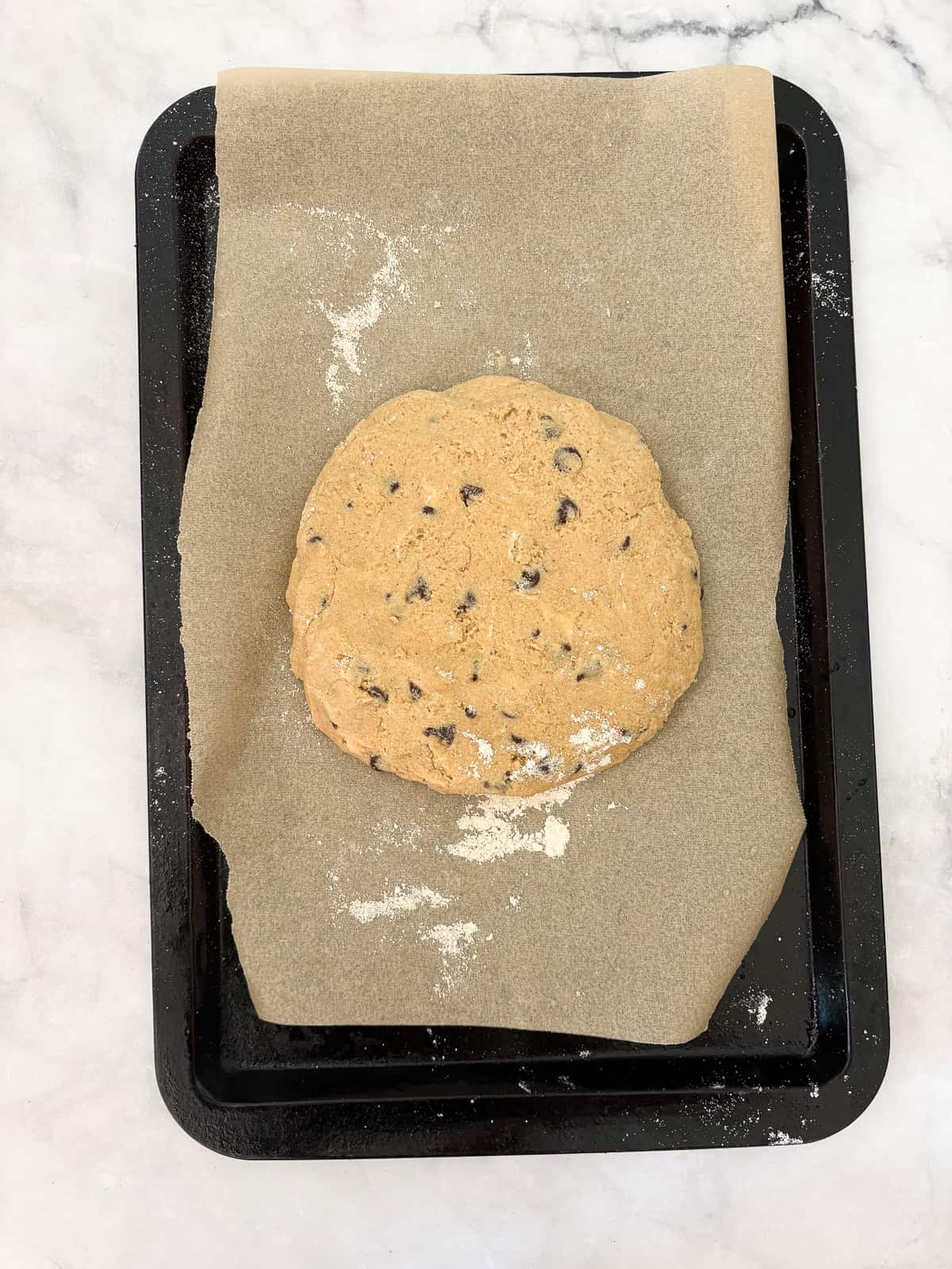 Bakery-style gluten-free chocolate chip scones with crisp edges, soft centers, and plenty of chocolate. Made just with oat flour! Gluten free chocolate chip scones dough patted into a round.