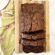 A sliced loaf of gluten free chocolate zucchini bread on a cutting board.