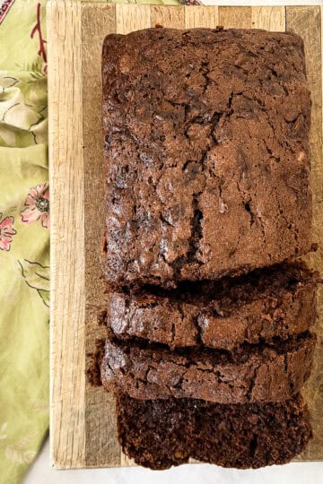 A sliced loaf of gluten free chocolate zucchini bread on a cutting board.