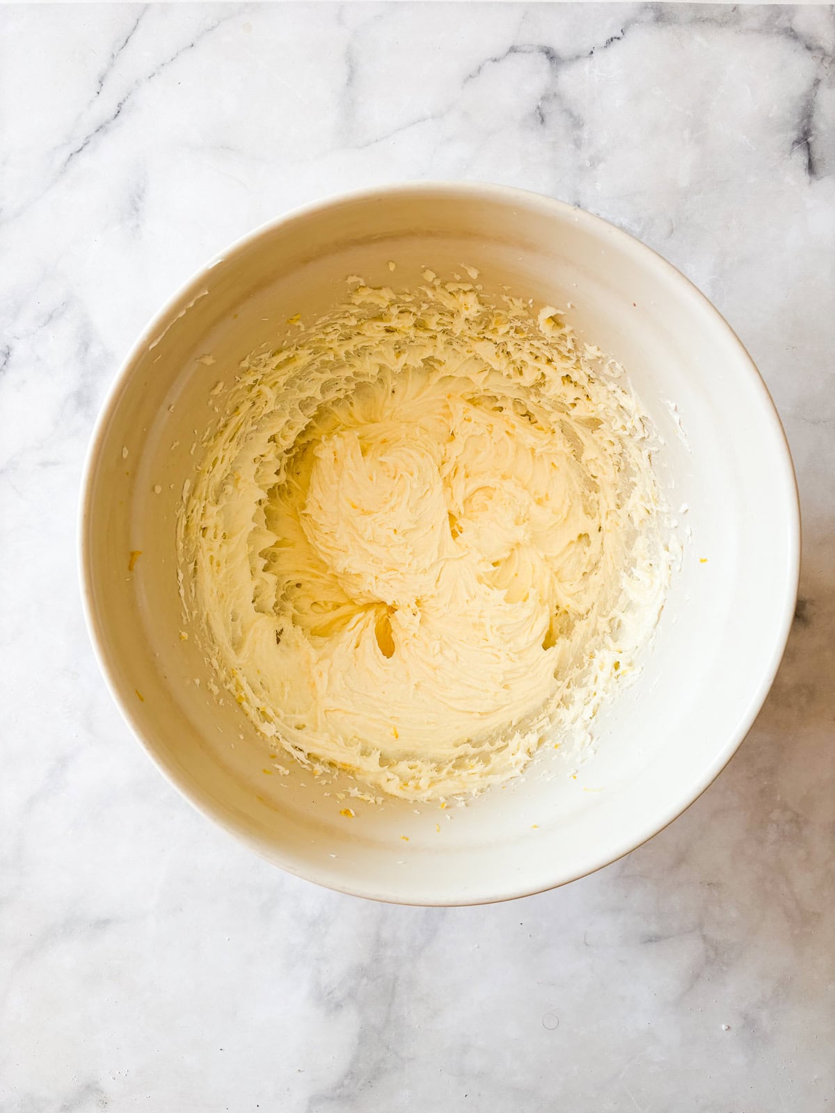 This rich and velvety gluten free lemon pound cake stays moist and tender for days! Made with oat and almond flour, cream cheese, and butter! Butter and cream cheese are creamed in a bowl for lemon pound cake.