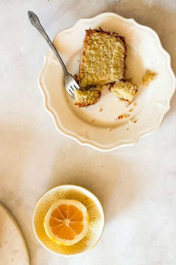 A slice of gluten free lemon pound cake on a plate with a fork.